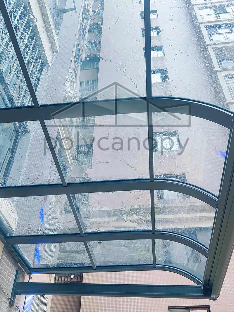 Polycarbonate canopy installed in front of a window, offering quiet and elegant rain protection